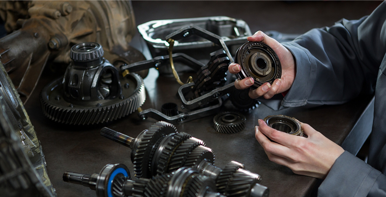 Mechanic inspecting differential gears, bearings and ring and pinion assembly to diagnose gear whine and premature wear